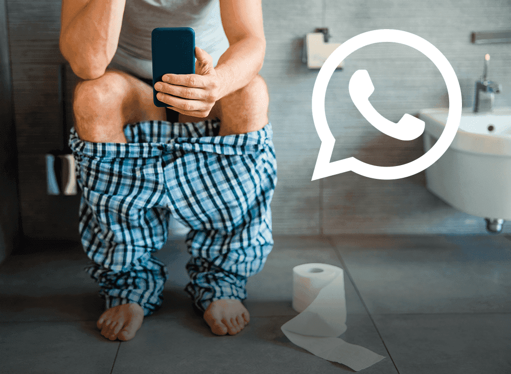 Mann auf der Toilette mit Smartphone.