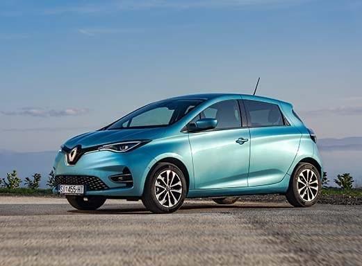 Helles türkisfarbenes Renault Clio, geparkt auf einer Schotterstraße.
