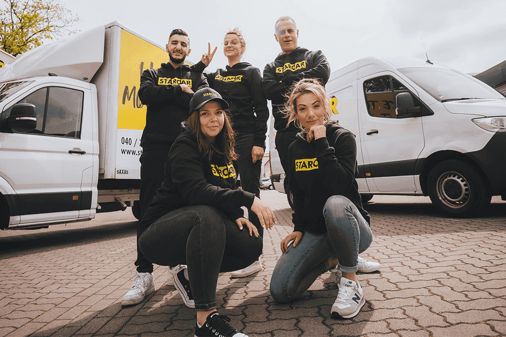 Team of STARCAR employees posing in front of a white van.