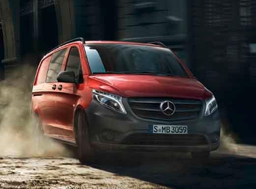 Red Mercedes-Benz Vito Mixto driving along a sandy road.