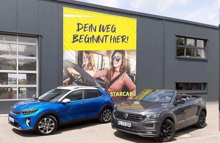 STARCAR Autovermietung Station Würzburg: blaue und graue Cabrios vor dem Gebäude.
