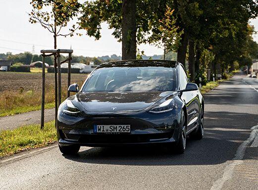 Schwarzes Tesla Modell 3 Elektroauto auf der Straße.